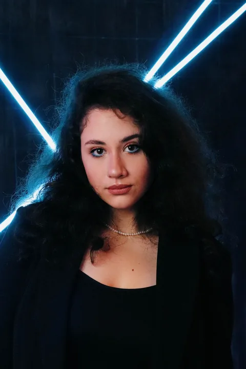 Licensed cinematic portrait in a dark suit with neon lighting